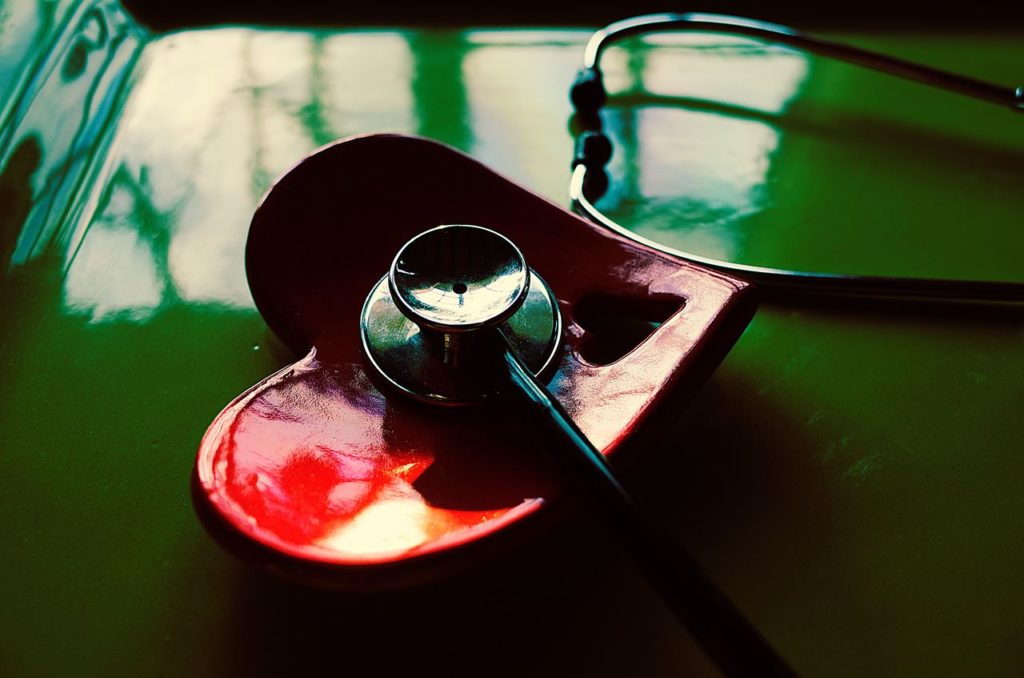 Image of a doctor's stethoscope on a table and in a tray in the shape of a heart