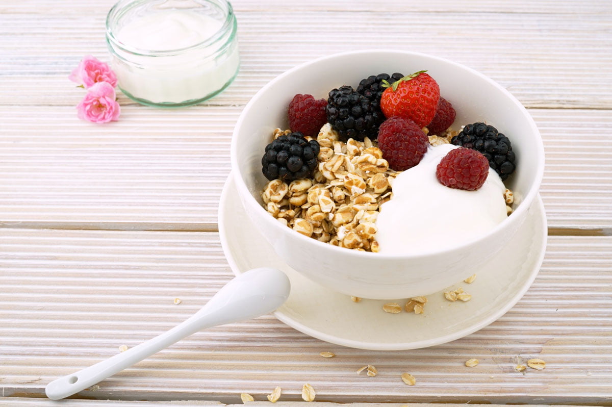 Image of yogurt, fruit and granola in a bowl on a table, which can contain the probiotic lactobacillus rhamnosus