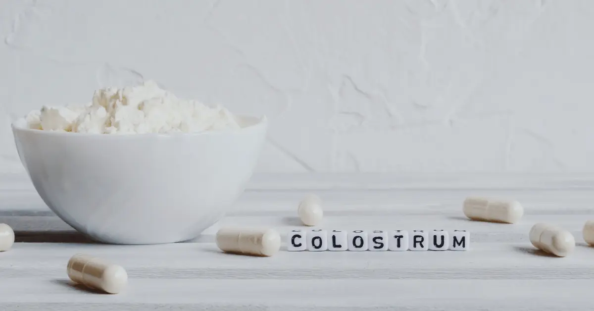 colostrum in letter blocks on table with powder and capsules